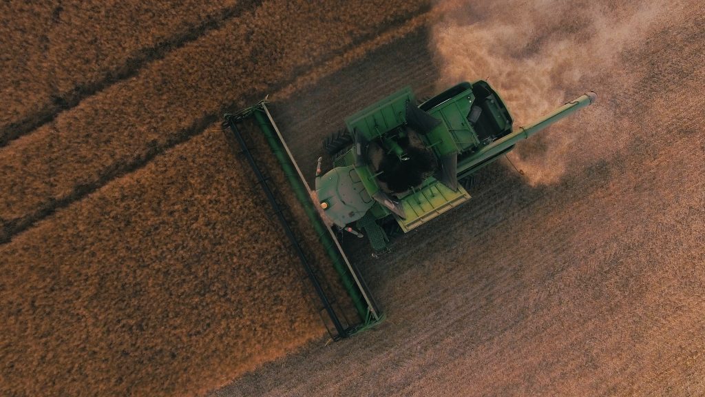 Overhead view of large combine mowing under wheat or corn